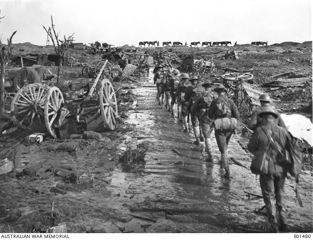 Idiot Corner, Ypres, 5 November 1917. Men and pack mules rounding Idiot Corner, on Westhoek Ridge, in Belgium, moving up to the front line. To follow the duckboard and corduroy track was to be seen silhouetted against the skyline, both from the Australian position and that of the enemy - before he was driven from Broodseinde Ridge. But passage over any part other than the top of the ridge was impossible owing to mud. At this point many transports and guns were wrecked by the constant shellfire, and others were lost in the morass. One vehicle actually sank out of sight in the ooze a little to the right of the picture. Australian War Memorial collection E01480